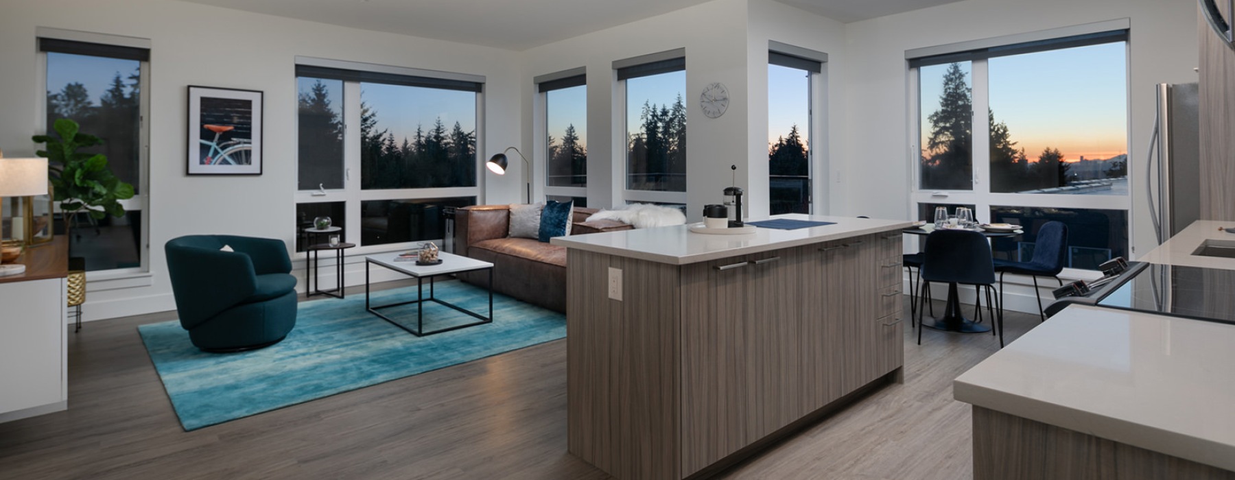 open concept apartment interior brightened by many large windows and recessed lights